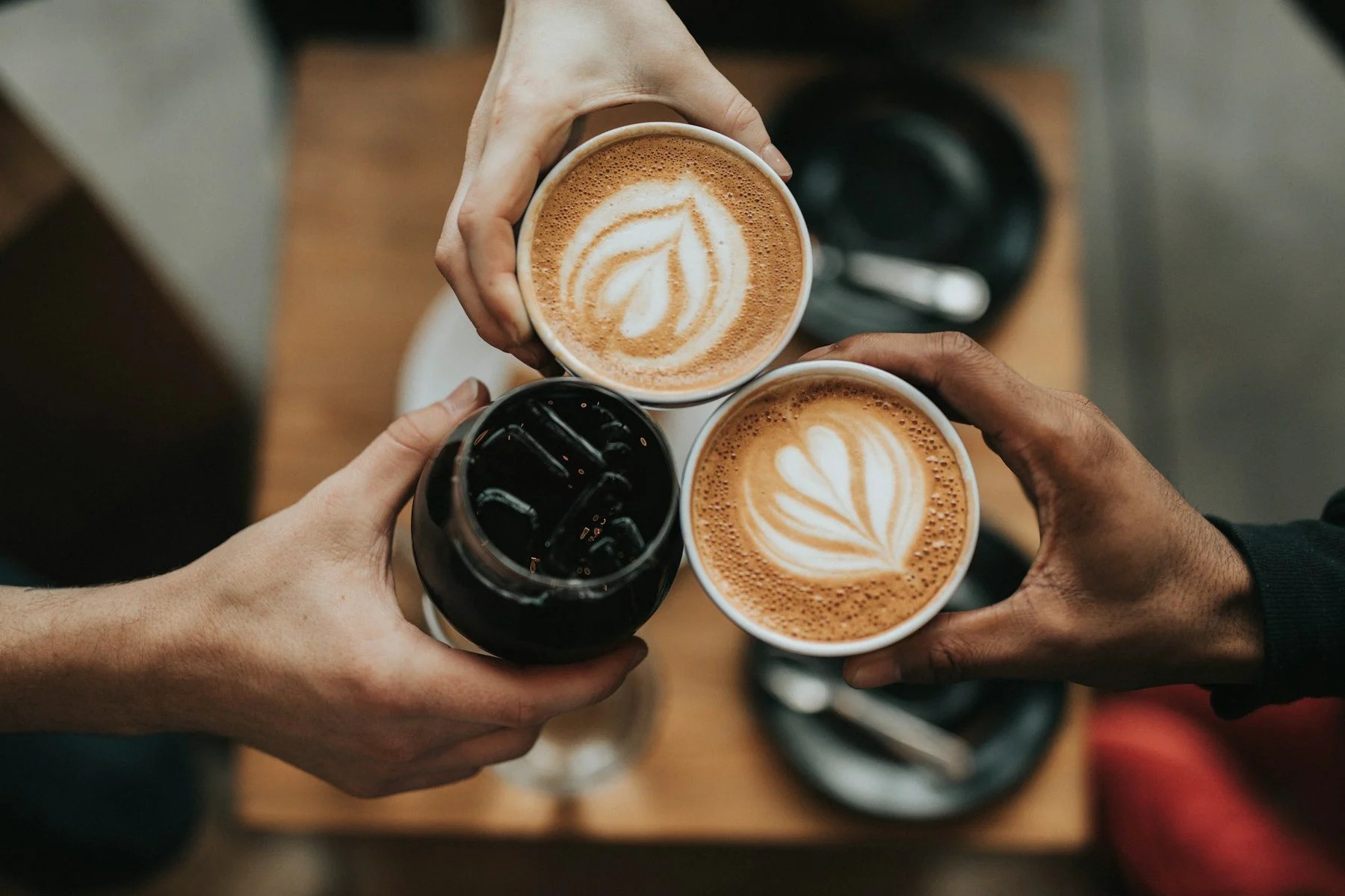 Barista připravuje cappuccino s pěnou v bílém šálku